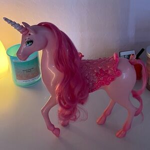 Pink sparkly children’s unicorn toy with saddle.